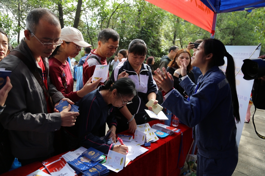 活动出发点，新颖的“电力普法护照”受到了众多市民的追捧，供不应求，图为江门供电局工作人员在向市民说明活动规则。温水植摄