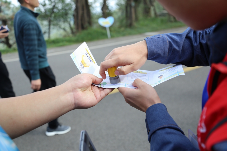 江门供电局别出心裁地在活动现场设置三个宣传点，派给群众一本“电力普法护照”，每到一个地方加盖一个印章，集齐三个印章可以在终点换取一份礼品，这个方式大大提高了群众的参与度。温水植 摄