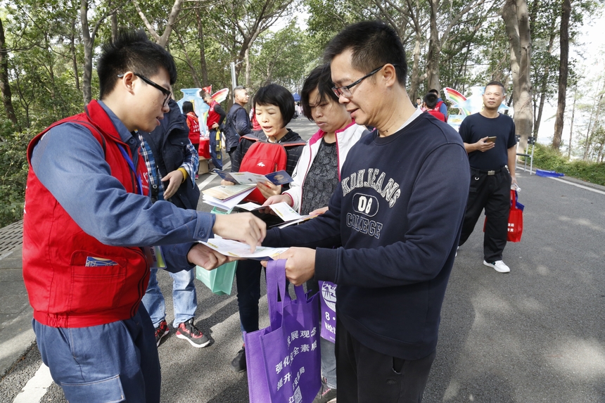江门供电局别出心裁地在活动现场设置三个宣传点，派给群众一本“电力普法护照”，每到一个地方加盖一个印章，集齐三个印章可以在终点换取一份礼品，这个方式大大提高了群众的参与度。甄一飞 摄