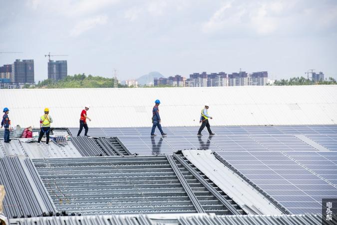 3、2022年6月23日，位于广西梧州市藤县广西新舵陶瓷有限公司屋顶光伏施工现场，南方电网广西新电力藤县供电公司党员服务队正为该企业屋顶光伏发电项目进行检查指导。工人们忙着安装光伏发电组件，一派繁忙景象。（何华文）