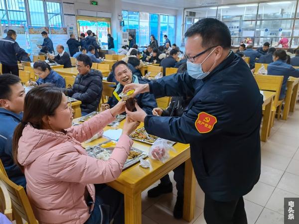 在饭堂把防疫茶送到员工手中