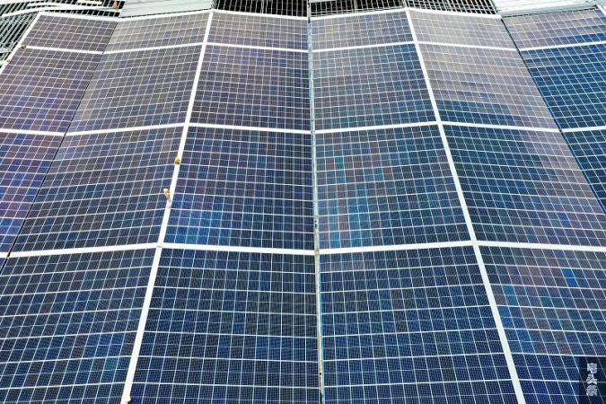 10、2022年6月23日，位于广西梧州市藤县广西新舵陶瓷有限公司屋顶光伏施工现场，南方电网广西新电力藤县供电公司党员服务队正为该企业屋顶光伏发电项目进行检查指导。工人们忙着安装光伏发电组件，一派繁忙景象。（何华文）