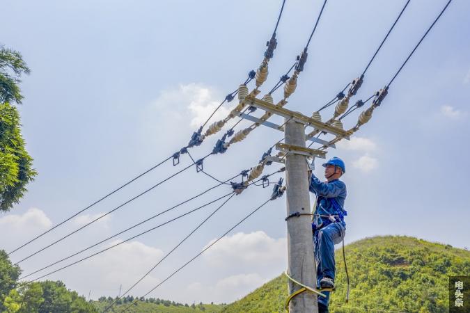 1、2021年7月26日，广西梧州市藤县古亮塘村，南网广西新电力藤县供电公司员工在进行线路检修维护。（何华文）