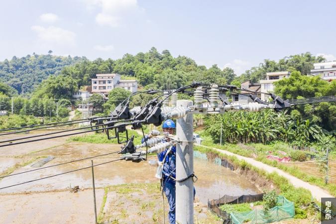 6、2021年7月26日，广西梧州市藤县古亮塘村，南网广西新电力藤县供电公司员工在进行线路检修维护。（何华文）