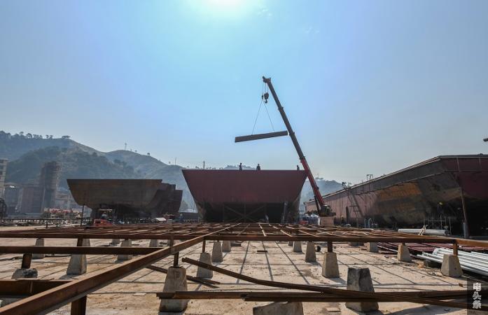 9、2021年12月10日，广西藤县顺舟造船有限公司造船基地，放眼望去，船台上满满架设着正在修造的船舶，工人们忙碌地穿行在货轮之间进行焊接、打磨、喷漆等工作。（何华文）