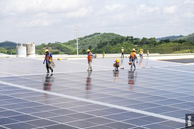 13、2022年6月23日，位于广西梧州市藤县广西新舵陶瓷有限公司屋顶光伏施工现场，南方电网广西新电力藤县供电公司党员服务队正为该企业屋顶光伏发电项目进行检查指导。工人们忙着安装光伏发电组件，一派繁忙景象。（何华文）