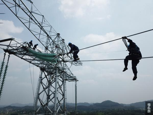 2020年3月24日，广东电网能源发展有限公司高空作业人员正在铁塔上展开金具安装。陈海东 摄