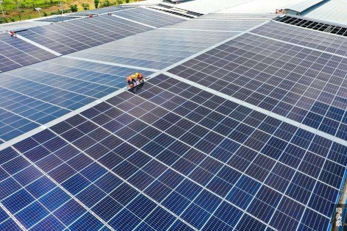 7、2022年6月23日，位于广西梧州市藤县广西新舵陶瓷有限公司屋顶光伏施工现场，南方电网广西新电力藤县供电公司党员服务队正为该企业屋顶光伏发电项目进行检查指导。工人们忙着安装光伏发电组件，一派繁忙景象。（何华文）